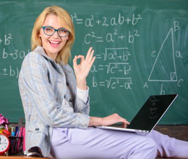 Kadın öğretim üyesi biliyorum nasıl dokunmatik modern nesil kal. Kadın öğretmen dizüstü sit tablo sınıf kara tahta arka plan tutun. Resmi olmayan çevre faydaları okuyor. Öğretmen modern nesil