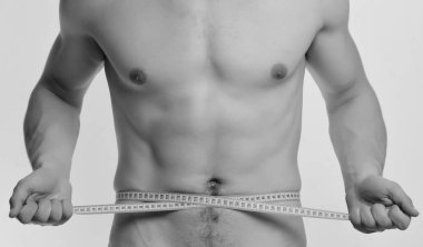 Güçlü kasları ile sporcu bel veya sixpacks ölçer. Beyaz arka plan üzerinde çıplak göğüs adamla. Adam bandı ile