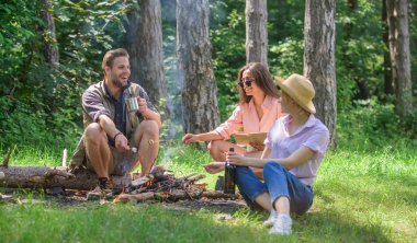 Hafta sonu harika vakit. Şirket yürüyüşçü piknik kavurma Marshmallow abur cubur yemek yeme. Var snack için bir ara verelim. Şirket arkadaşlar gıda Aperatif doğa arka plan yemek. Yürüyüşçüler piknik üzerinde