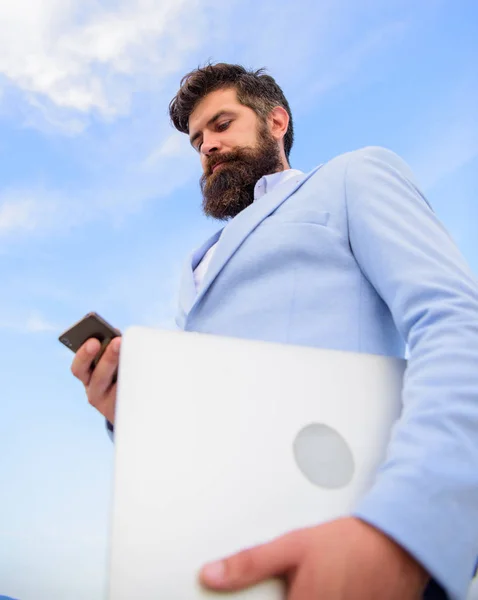 Top qualities of excellent manager. Man well groomed bearded hipster holds laptop blue sky background. Guy formal suit modern technology manager entrepreneur. Keep in touch. Modern communications