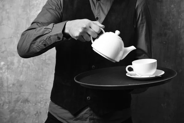 Mężczyzna ręce trzymać zestaw do herbaty na tle beżowej ściany. Usługi i restauracja catering koncepcja. Barman serwuje herbaty — Zdjęcie stockowe