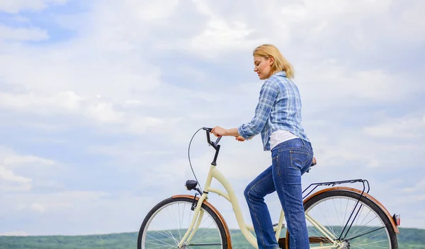 女人骑自行车的天空背景。如何学习骑自行车作为一个成年人。活跃的休闲。女孩骑自行车。最健康最环保和最满意的自我运输形式 — 图库照片