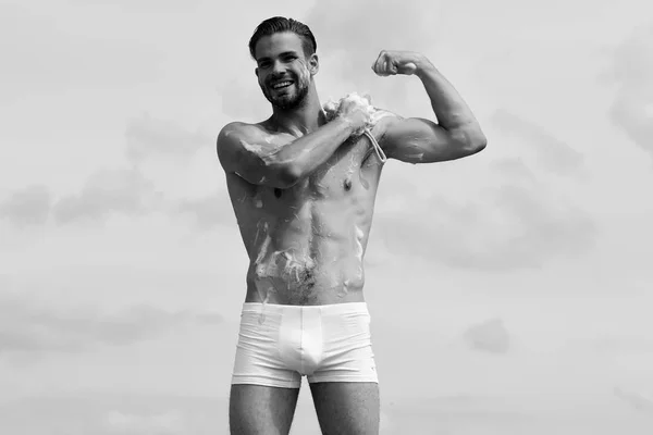 Macho wassen met spons. Mannelijk lichaam met sexy torso. Man in onderbroek bedekt met schuim aantonen van spieren — Stockfoto