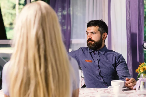 Casal apaixonado segura xícaras de café na mesa. Hora do almoço e conceito de comunicação. Menina com cabelo loiro — Fotografia de Stock