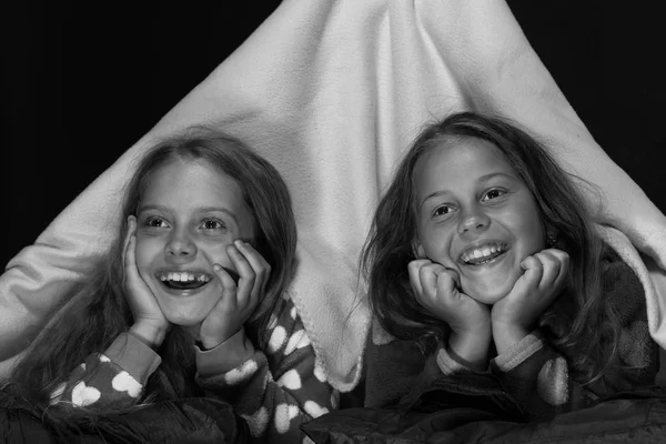 Los niños y el concepto de tiempo divertido. Niños vistiendo pijamas rojas viendo televisión en tienda de mantas —  Fotos de Stock