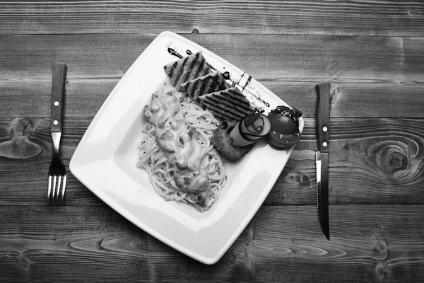 Pasta med vit sås och inredning på trä bakgrund. — Stockfoto