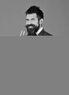 Neşeli sakallı iş adamı burada duruyor. Akıllı takım elbiseli adam mavi arka planda şampanya içiyor..