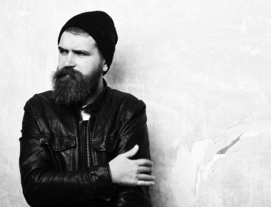 Sakallı adam, uzun sakallı. Vahşi beyaz, ciddi, tıraşsız hippi siyah deri ceket, şapka ve beyaz gömlek giyiyor. Duvarın arka planında, fotokopi odası..