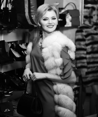 Arka planda sarı saçlı ve dükkanlı bir bayan var..