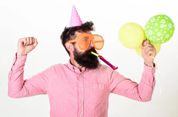 戴着热气球的家伙庆祝。男子在繁忙的脸上胡子和胡子吹成党的号角, 白色背景。时髦的大太阳镜庆祝生日。庆祝概念 — 图库照片