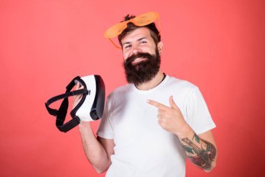 Alternatif gerçeklik. Sakallı adam hippi sanal gerçeklik kulaklık ve çok güneş gözlüğü kırmızı arka plan ile. Hangi gözlük louvered veya sanal seçin. Adam ne tercih gerçek veya sanal karar