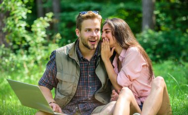 Modern teknolojileri herhangi bir çevre koşullarında çalışmak için fırsat verir. Çift gençlik eğlence dizüstü bilgisayar ile açık havada harcamak. Adam ve yeşil çayır laptop ile çalışan kız. Serbest fırsat