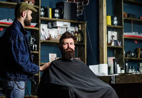 Hipster client got new haircut. Barber with hair clipper looking at mirror, barbershop background. Haircut concept. Professional master checking result while client sits in chair. Barber done haircut — Stock Photo, Image
