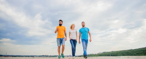 United group purposefully moves forward. Friendship tested for years. Men and woman walks dramatic cloudy sky background. True friendship grow with destiny obstacles. United threesome true friends