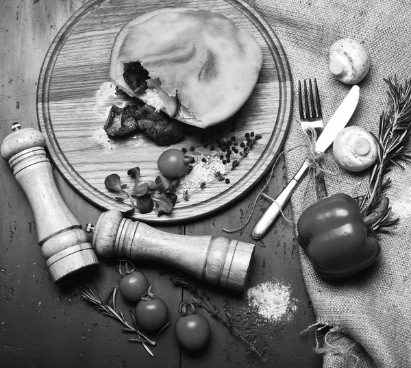 Roasted meat in small dough pocket on wooden board — Stock Photo, Image