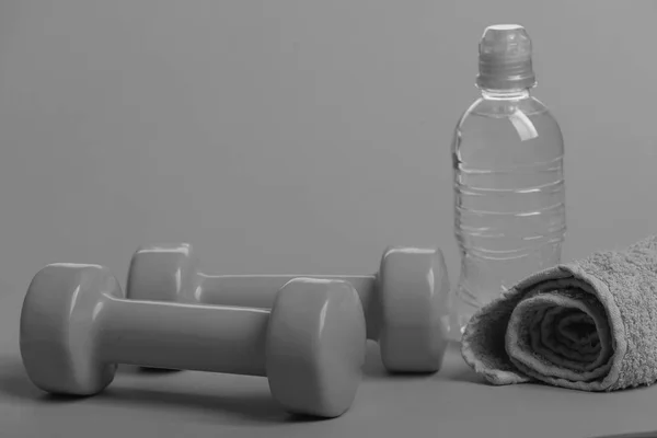 Dumbbells in bright green color, water bottle and cloth