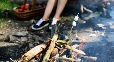 Şenlik ateşi ve arka plan üzerinde duman ile Stick Marshmallow. Lokum sopa üzerinde tutarak. Roasty, sıcak şekerleme piknik özetin özeti gibi tadı vardır. Nasıl şekerleme kızartmak için