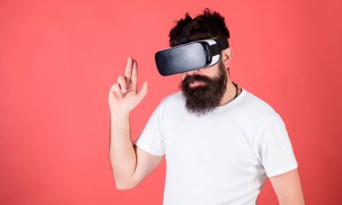 En iyi shooter Vr. Man için kırmızı bir arka plan üzerinde sanal gerçeklik kulaklık ile hippi sakallı. Adam el hareketi olarak silah oyun shooter oyun Vr gözlük. Birinci kişi ateş gösterir nasıl bağımlılık Vr olabilir