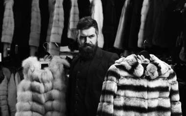 Adam düşünceli yüz kürk moda mağaza içinde gösterir..