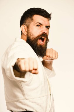 Jiu Jitsu ana uygulamaları saldırı veya savunma duruş. Sağlıklı yaşam ve spor kavram. Kızgın yüz üniformalı adam karate. Beyaz arka plan üzerinde beyaz kimono içinde sakallı.