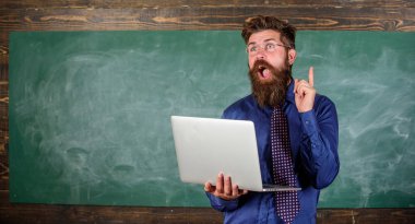 Okul yenilik. Uzaktan eğitim kavramı. Öğretmen modern dizüstü sörf internet kara tahta arka plan ile adam sakallı. Yenilikçi öğretmen giyim gözlük ve kravat tutan laptop internet'te sörf
