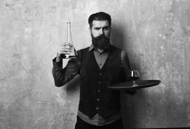 Garson tepside içki taşıyor. Resmi giyinmiş bir adam.