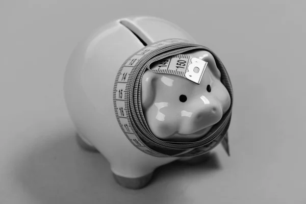Piggy bank tied with measuring tape showing number 150 — Stock Photo, Image