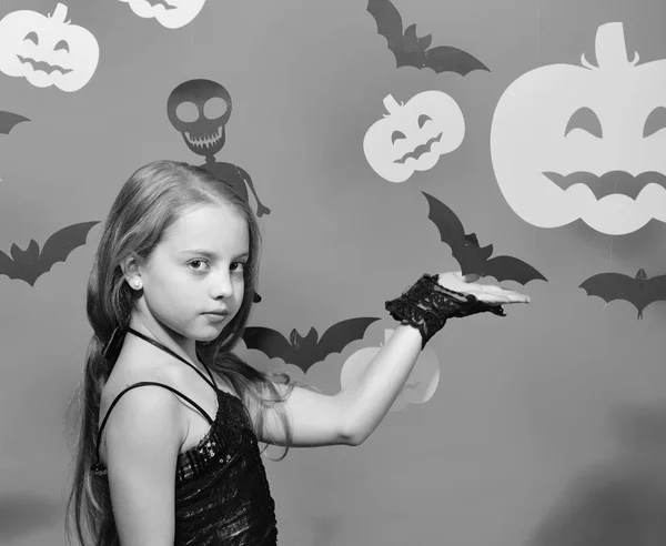 Menina com rosto sério no fundo vermelho mostrando morcegos, abóboras — Fotografia de Stock