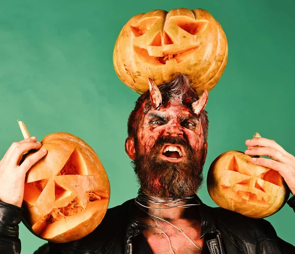 Monstre avec des décorations d'octobre. Homme portant un maquillage effrayant tient citrouilles — Photo