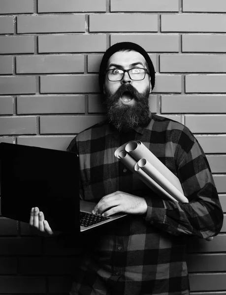 Bärtiger brutaler kaukasischer Hipster mit Laptop und Bastelpapier — Stockfoto