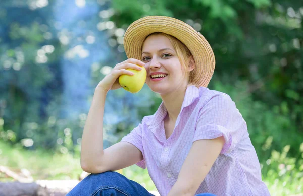 Un bocadillo saludable. Mujer sombrero de paja sentarse prado celebrar fruta de manzana. Su elección es una vida sana. Chica en el picnic en el bosque en el día soleado. Chica disfrutar de picnic con merienda saludable manzana fruta naturaleza fondo —  Fotos de Stock