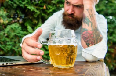 Fan seyretmek akarsu online oturup açık havada içki bira Teras. Acımasız adam bira ile eğlence ve spor oyunu. Futbol fanatiği hipster izle oyun dizüstü bilgisayar ekranında sakallı. Oyun sonucu ile hayal kırıklığına uğrattı