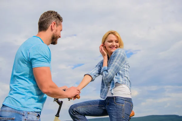 asual acquaintance concept. Man with beard and shy blonde girl on first date. Woman feels shy in company with attractive macho. Couple just meet to hang out together. Rolling romance or bike date