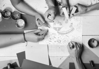 Sanatçı ahşap masa boyalar ve renkli kağıt ile. İşaretleri erkek ve kadın elinde beyaz kağıt üzerine çizmek