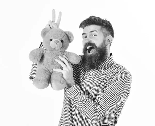 Hipster with beard or father plays with teddy bear or plush toy. Fatherhood concept. Man with happy face holds soft toy — Stock Photo, Image
