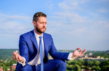 İşadamı resmi takım elbise lotus poz ve meditasyon oturup açık havada. Girişimci dakika dinlenip, meditasyon bulmak. Adam zihnini açık tutmaya çalış. Gevşeme tekniği. Ruhu içinde sakin tutmak