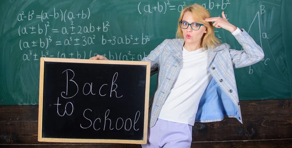 Une enseignante tient un tableau noir à l'inscription de l'école sur fond de tableau. Postulez pour une offre éducative sensationnelle. Offre spéciale vente à prix réduit saison scolaire. Offre spéciale retour à l'école — Photo