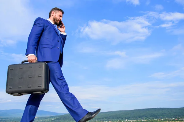 Gehen Sie weiter in Richtung Ihres Ziels. Geschäftsmann formalen Anzug trägt Aktentasche Himmel Hintergrund. Geschäftsmann, der Geschäftsprobleme am Telefon löst. nie aufhören. Unternehmer in Bewegung, zielgerichteter Ausdruck — Stockfoto