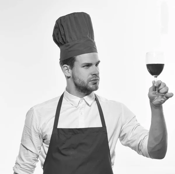 Kock i Bourgogne uniform med glas rött vin. Laga mat med nöjd ansikte ser på vinglas. Italienska dryck koncept. — Stockfoto