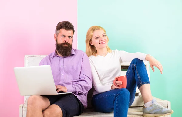 Man works as internet technologies expert on freelance. Freelance benefits. Girl enjoy drink while husband freelancer works with laptop. Woman smiling face drink tea or coffee near man working