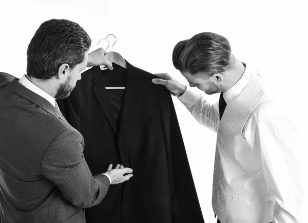 Los hombres de negocios tienen la chaqueta en las manos. Concepto de ropa de negocios. Asistente de tienda muestra chaqueta a joven sobre fondo blanco . — Foto de Stock