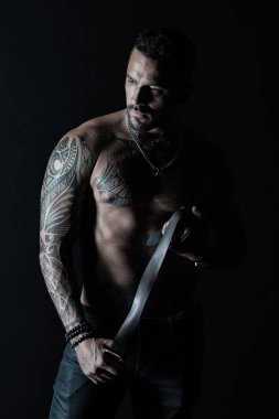 Kot pantolon deri kemer ile manken. Dövme tasarım cilt üzerinde olan adam. Kas gövde sakallı adam. Dövmeli kol ve göğüs ile sporcu. Fitness ve spor vintage filtre ile ilgilenmek