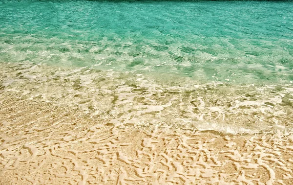 海の背景。砂の上の波状水背景 — ストック写真