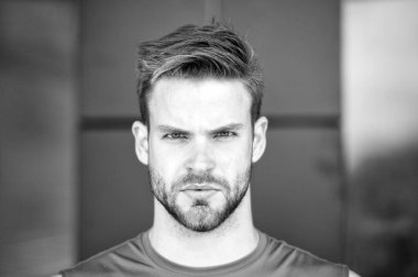 Kıl katı yüz, kentsel arka plan üzerinde olan adam. Sakal veya tıraşsız adam görünüyor yakışıklı ve sağlıklı bir cilt ile serin adam. Adam sakallı ve çekici görünümü ile ilgili umurunda değil. Metroseksüel kavramı