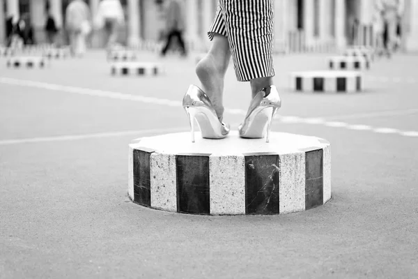 Hoge hak schoenen op vrouwelijke voeten op het stadsplein. Benen in glamour gouden schoenen Parijs, Frankrijk. Fashion schoenen op kolom buiten. Fashion stijl en vogue concept. luxe en trendy uitstraling concept. — Stockfoto