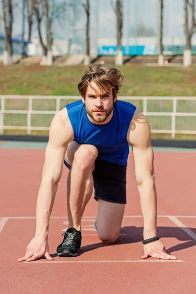 Athletischer bärtiger Mann mit muskulösem Körper, der sich auf der Laufstrecke streckt — Stockfoto