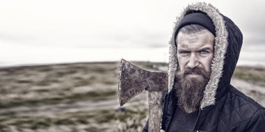 Sakallı yakışıklı ciddi adam dağ üstüne paslı balta ile