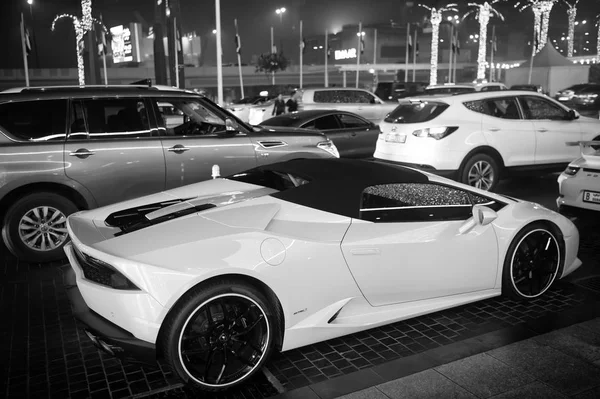 Роскошный суперкар Lamborghini Huracan желтого цвета припаркован рядом с торговым центром Дубая. Lamborghini является известным дорогим автомобилем марки — стоковое фото