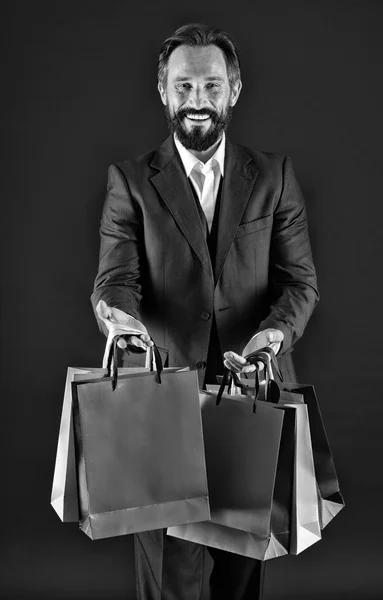 Köp koncept. Lycklig man köper i påsar. Skäggig man smile med köp. Inköpsorder, svart och vitt — Stockfoto