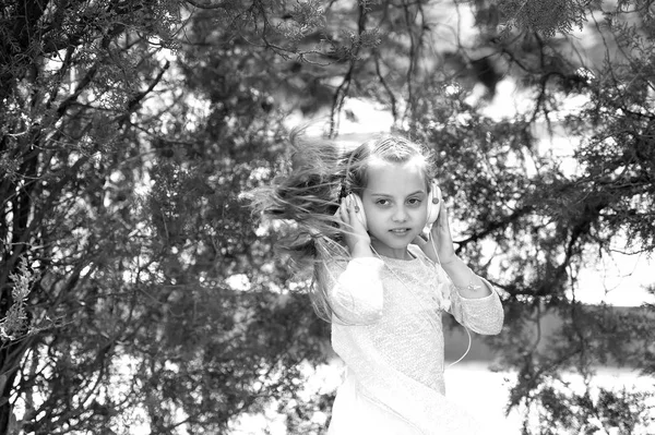Kleine Kinder genießen Musik im Freien mit Kopfhörern. Kindertänzerin mit langen fliegenden Haaren. Melodieklang und mp3. Mädchen tanzen zu Musik im Sommerpark. Sommerspaß und -freude — Stockfoto